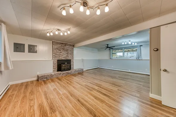 a view of empty room with wooden floor and fireplace