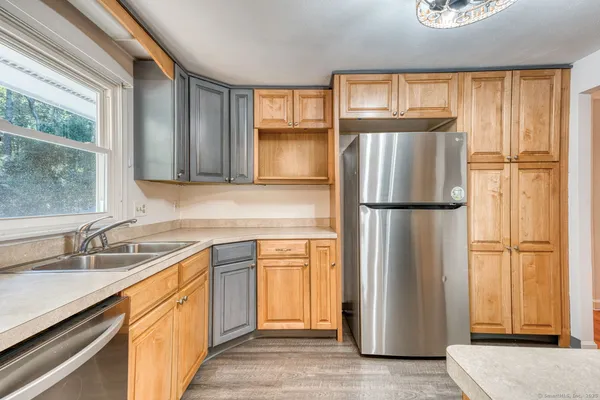 a kitchen with stainless steel appliances granite countertop a refrigerator and a sink