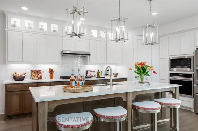 a kitchen with granite countertop a table chairs stove and cabinets
