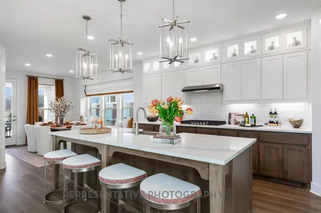 a kitchen with stainless steel appliances a table and chairs in it