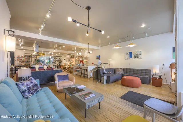 a living room with lots of furniture and view of kitchen