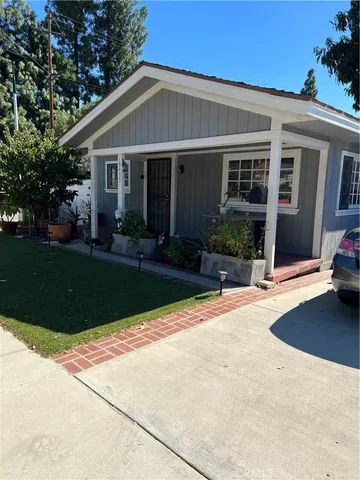 a front view of a house with a yard and plants