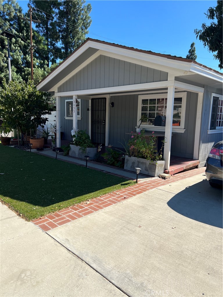 a front view of a house with a yard and plants