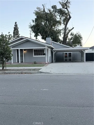 a front view of a house with a yard and trees