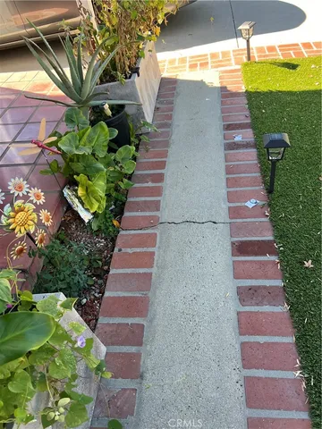 a pathway of a house with a yard