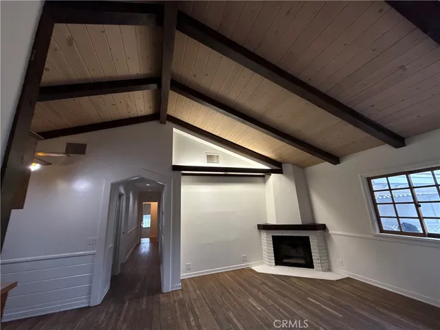 a view of empty room with wooden floor and fireplace