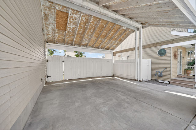 788 East Gables Street Midvale, UT 84047 - Photo 18 of 24 Carport featuring a concrete slab, slatted wood siding, and an exposed wood beam ceiling