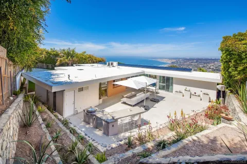 a view of a patio with furniture and a garden