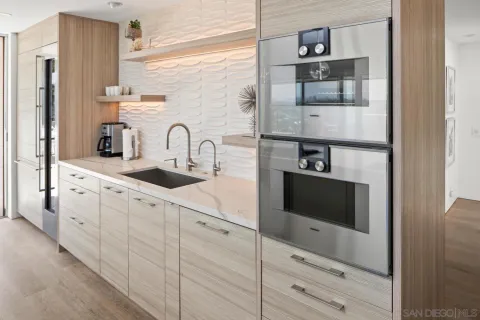 a kitchen with white cabinets and sink