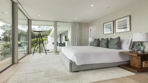 a spacious bedroom with a bed and glass wall painting