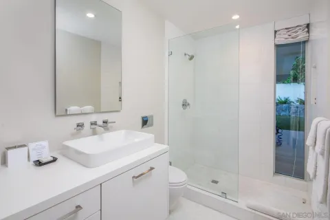 a bathroom with a sink a toilet and shower