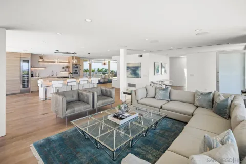 a living room with furniture and a view of kitchen