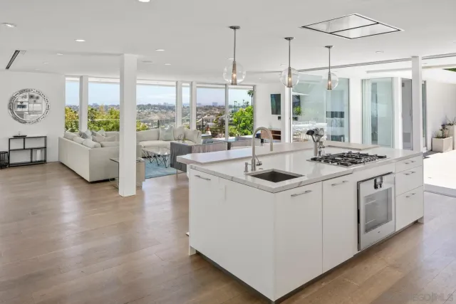 a kitchen that has a sink a stove and a wooden floor