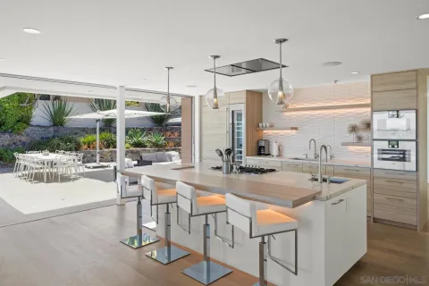 a kitchen with stainless steel appliances granite countertop a table and chairs in it