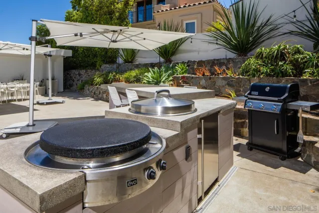 a view of a patio with table and chairs under an umbrella