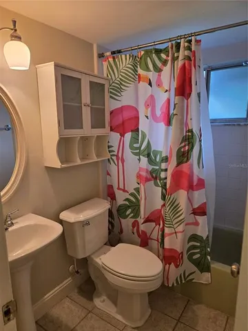 a white toilet sitting next to a bathroom sink and vanity