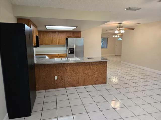 a kitchen with stainless steel appliances granite countertop a refrigerator a sink and a stove