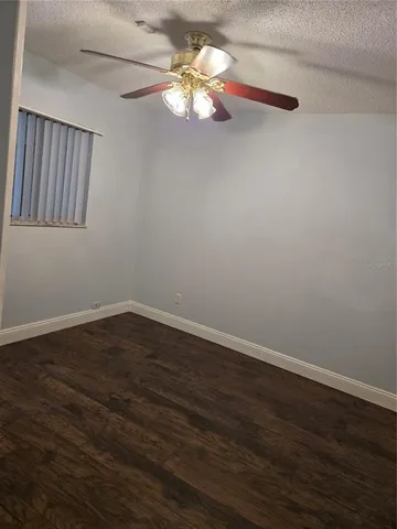 a view of wooden floor and a chandelier fan in a room