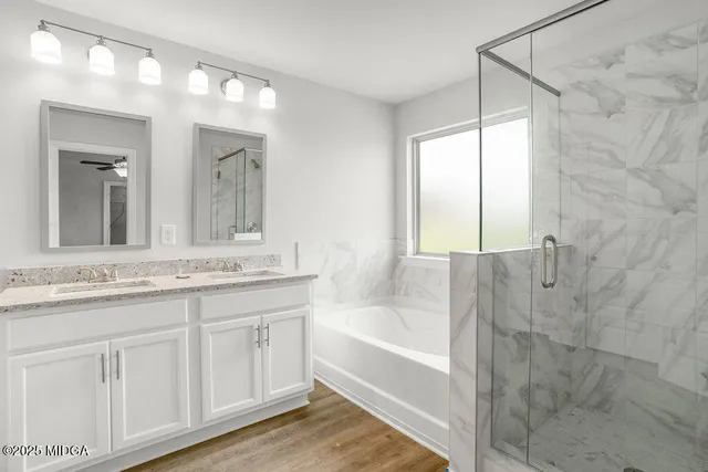 a bathroom with a granite countertop sink mirror and a bathtub