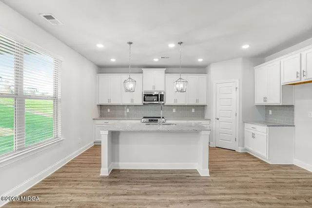 a kitchen with kitchen island sink stove and cabinets