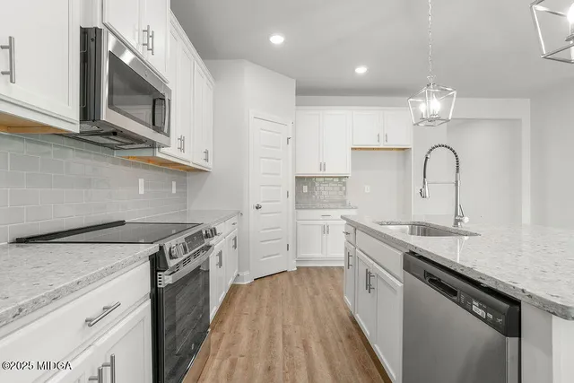 a kitchen with a sink stove top oven and cabinets