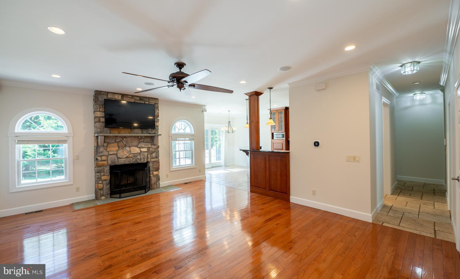 1060 West King Road Malvern, PA 19355 - Photo 11 of 90 an empty room with wooden floor a ceiling fan and a kitchen