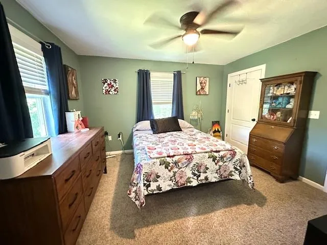 a bedroom with a bed a dresser next to a window