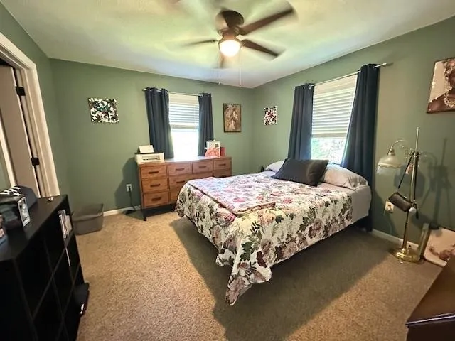 a bedroom with a large bed and a flat tv screen on dresser