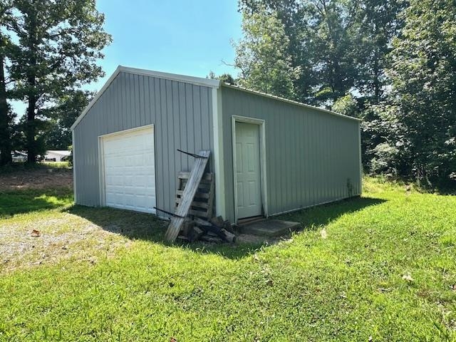 2082 Airport Ridge Road Linden, TN 37096 - Photo 26 of 29 a backyard of a house with plants and a tree