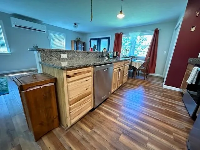 a kitchen with stainless steel appliances granite countertop wooden floors and sink