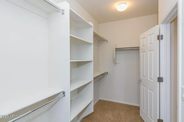 a view of walk in closet with empty racks