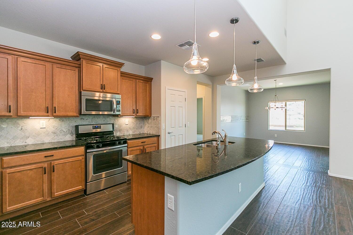 26833 North 14th Lane Phoenix, AZ 85085 - Photo 3 of 55 a kitchen with granite countertop a stove a sink dishwasher and a refrigerator with wooden floor