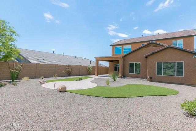 a view of a house with backyard and sitting area