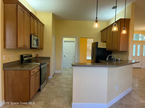 a kitchen with stainless steel appliances granite countertop a sink a refrigerator and a cabinets