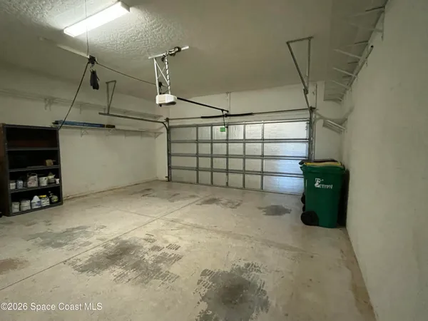 a backyard of a house with potted plants and large trees