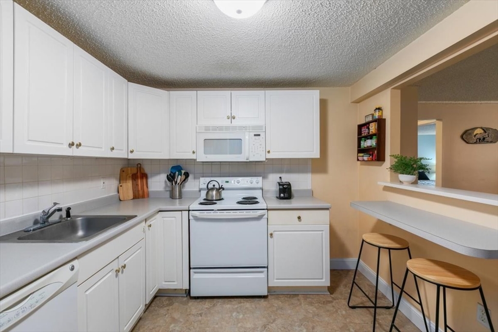 25 Clark's Road, Unit 101 Amesbury, MA 01913 - Photo 13 of 32 a kitchen with a sink cabinets and window
