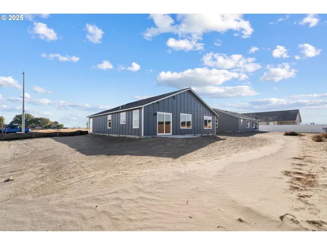 a open kitchen with a sink dishwasher a stove and white cabinets with wooden floor