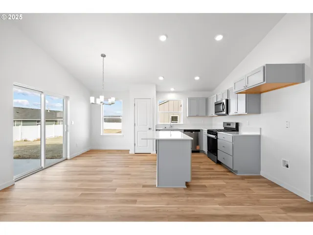 a kitchen with stainless steel appliances granite countertop a sink dishwasher a stove and a refrigerator