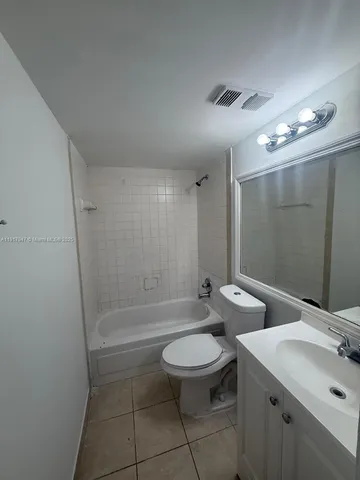 a bathroom with a toilet a sink a mirror and a bathtub