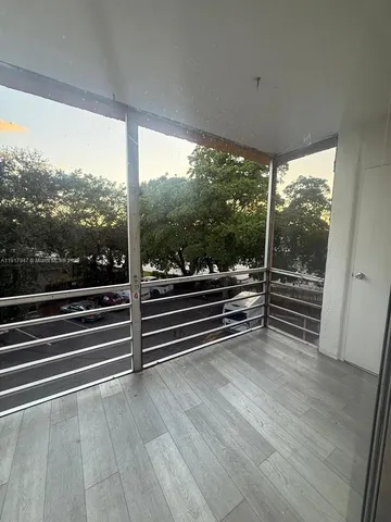 a view of a room with wooden floor and windows