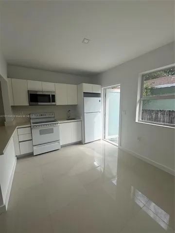 a view of a kitchen with a sink a stove and cabinets