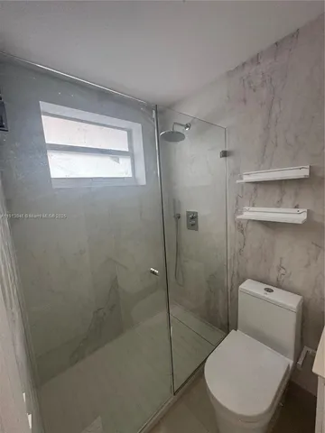 a bathroom with a toilet and a shower