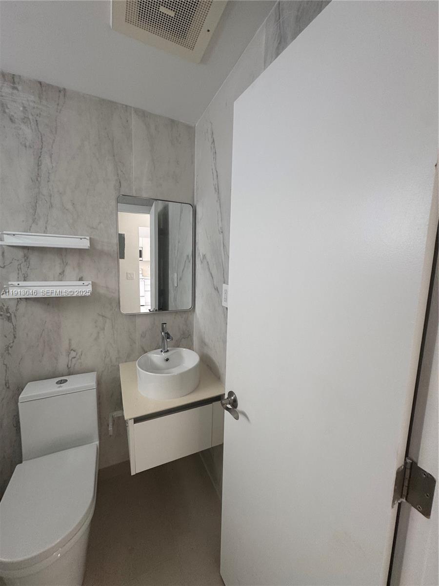 53 Northeast 56th Street, Unit 1 Miami, FL 33137 - Photo 10 of 10 a bathroom with a sink toilet and mirror