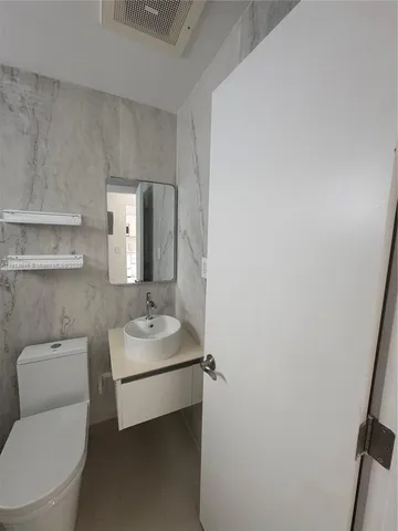 a bathroom with a sink toilet and mirror