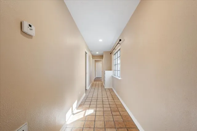 a view of a hallway with wooden floor and a white wall