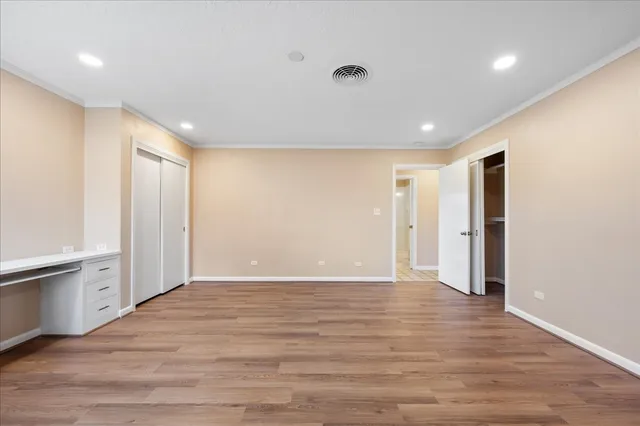 a view of an empty room with wooden floor