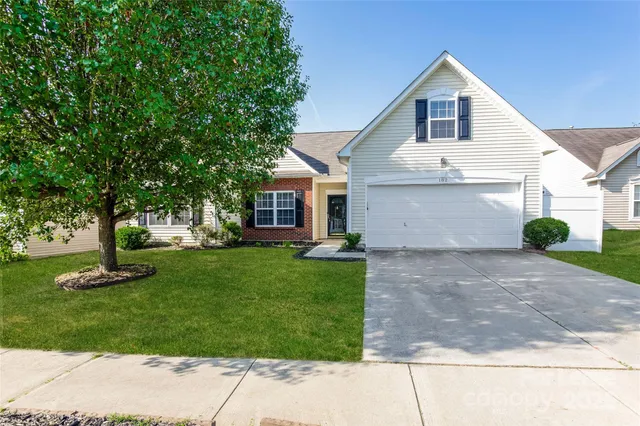 a front view of a house with a yard and trees