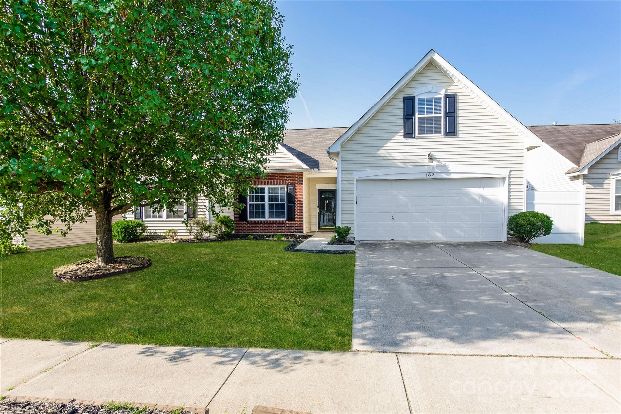 a front view of a house with a yard and trees