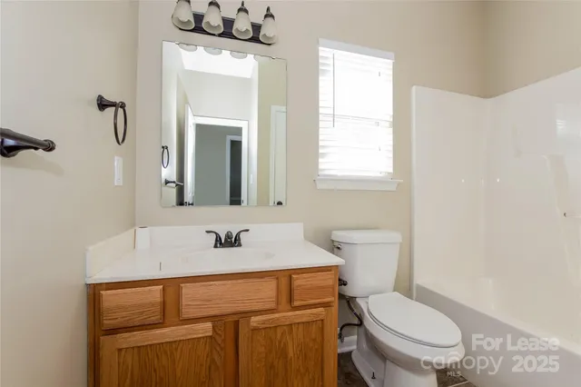 a bathroom with a sink a toilet and mirror