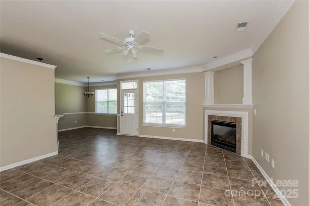 a view of an empty room with a fireplace and a window